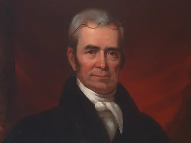 A portrait of John Marshall in dark robes, white cravat, and spectacles atop his head seated in front of red curtains