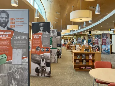 A display of banners from the museum's Determined exhibition on display in a library reading room.