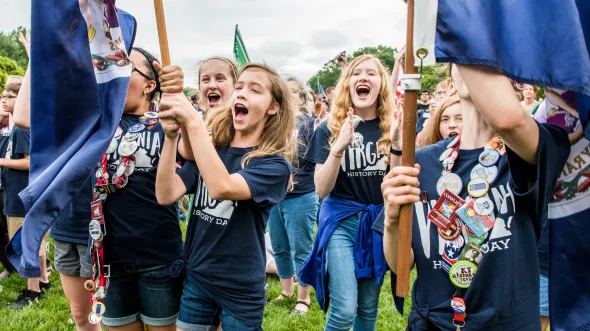 Girls holding flags celebrate at National History Day 