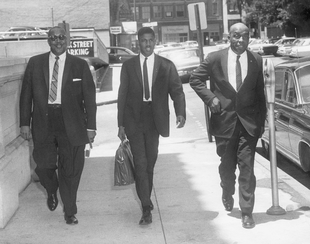 Black and white photograph of Frank D. Reeves, Henry L. Marsh III, and Samuel W. Tucker walking next to each other down a street. 