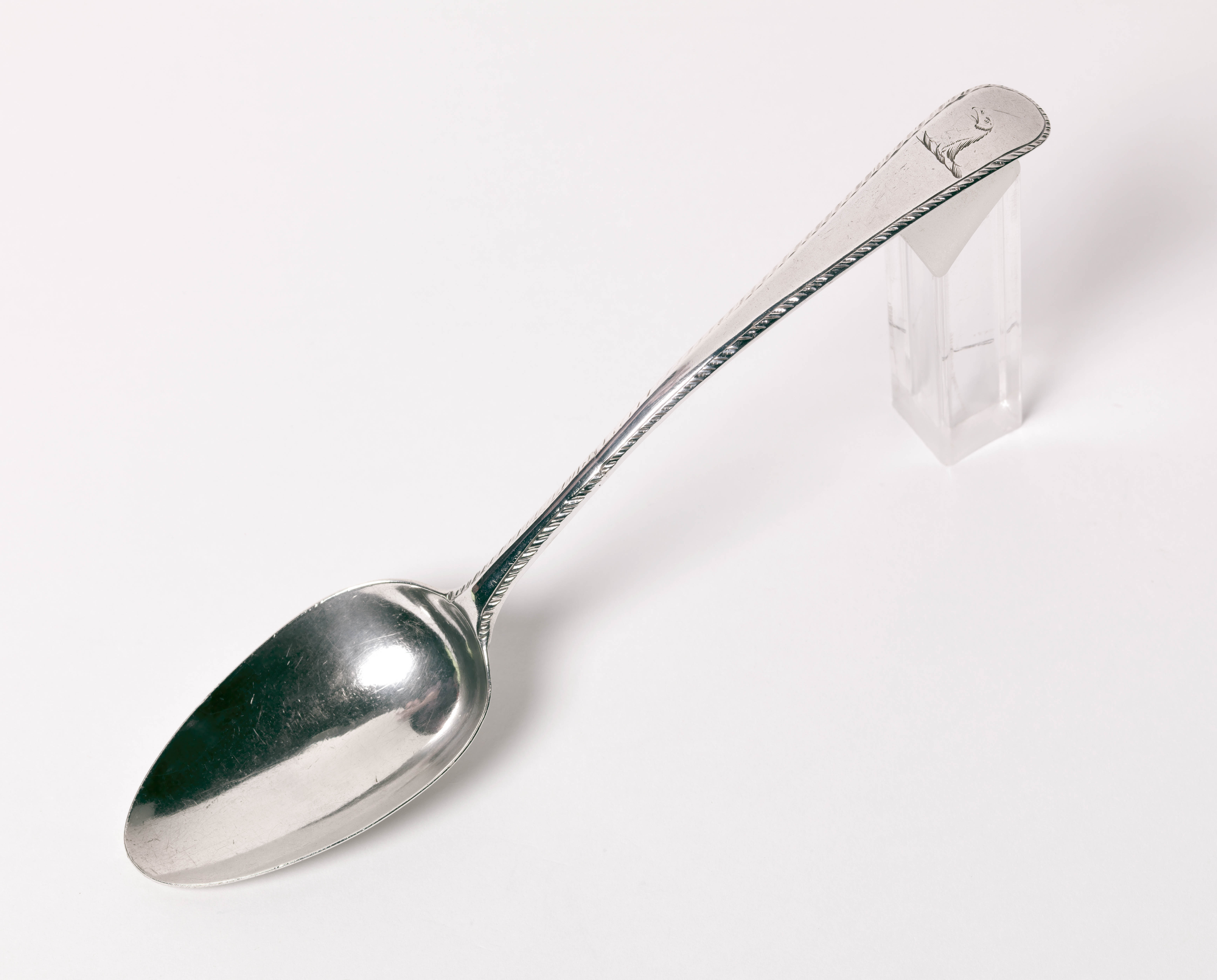 A silver spoon propped on a plastic block