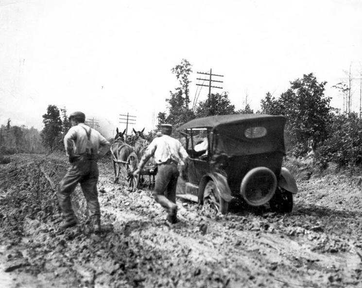 Auto Being Dragged Out of the Mud, 1917 (VHS accession number: 2000.186.454.b). Black and white photographic print of a car stuck in the mud along Route 1 near Dumfries, Virginia. Auto Being Dragged Out of the Mud, 1917