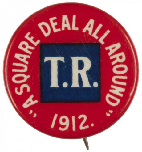Red button with a blue square design in the center with the initials, “T. R.” written in white; the text, “A SQUARE DEAL ALL AROUND / 1912” is written around the box. 