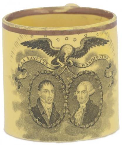 A yellow child’s cup with a portrait of Marquis de Lafayette and George Washington, with an eagle holding a ribbon with the words “LA FAYETTE, WASHINGTON” over the respective men. 