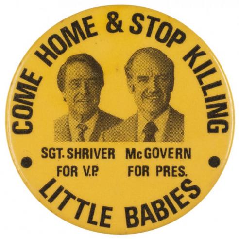  Yellow button with the text, “COME HOME & STOP KILLING LITTLE BABIES” around two black and white photographs of Sgt. Shriver and McGovern. 